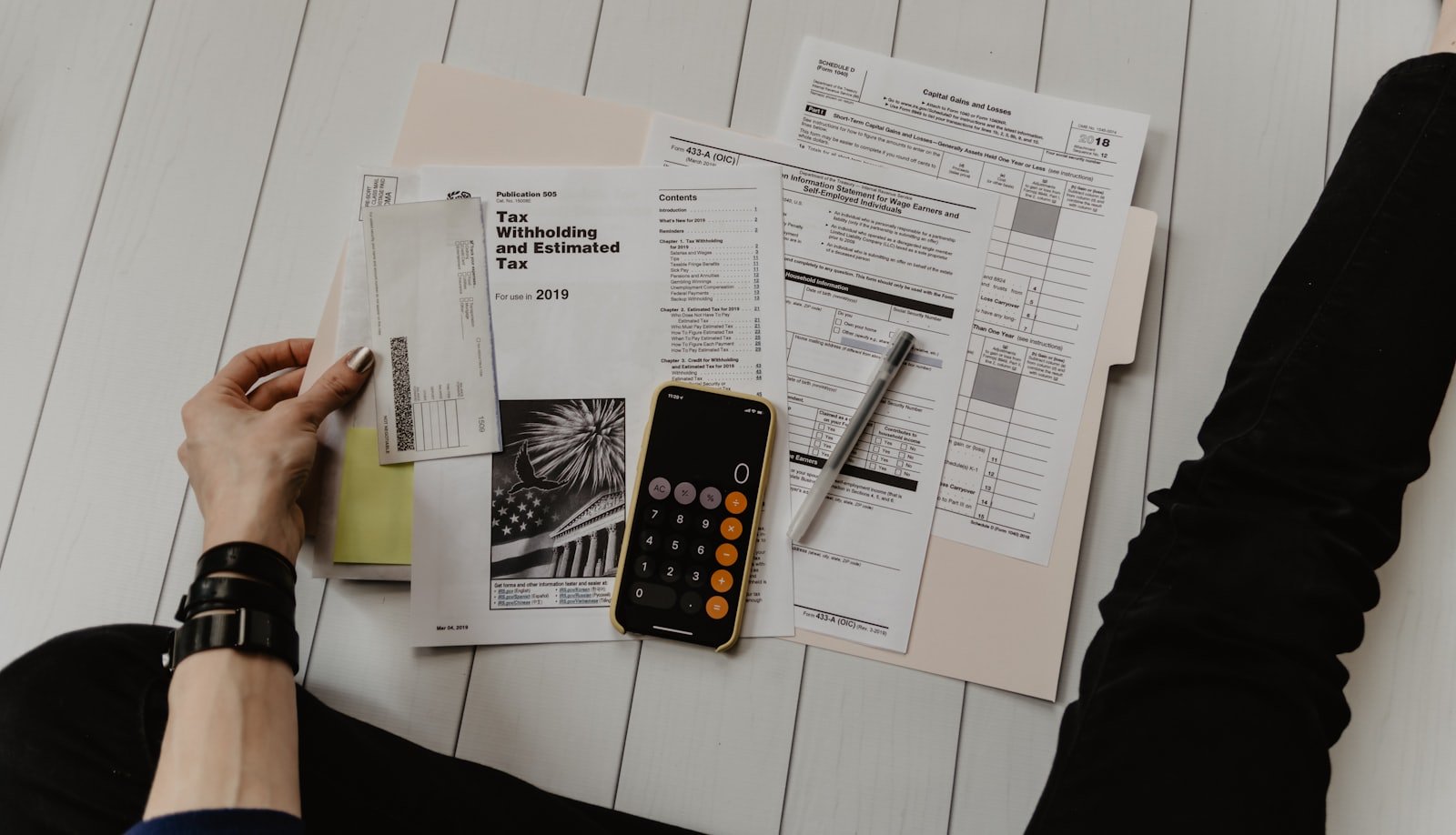 Close-up of a printed insurance contract covered in dense small print, with a calculator resting on the page