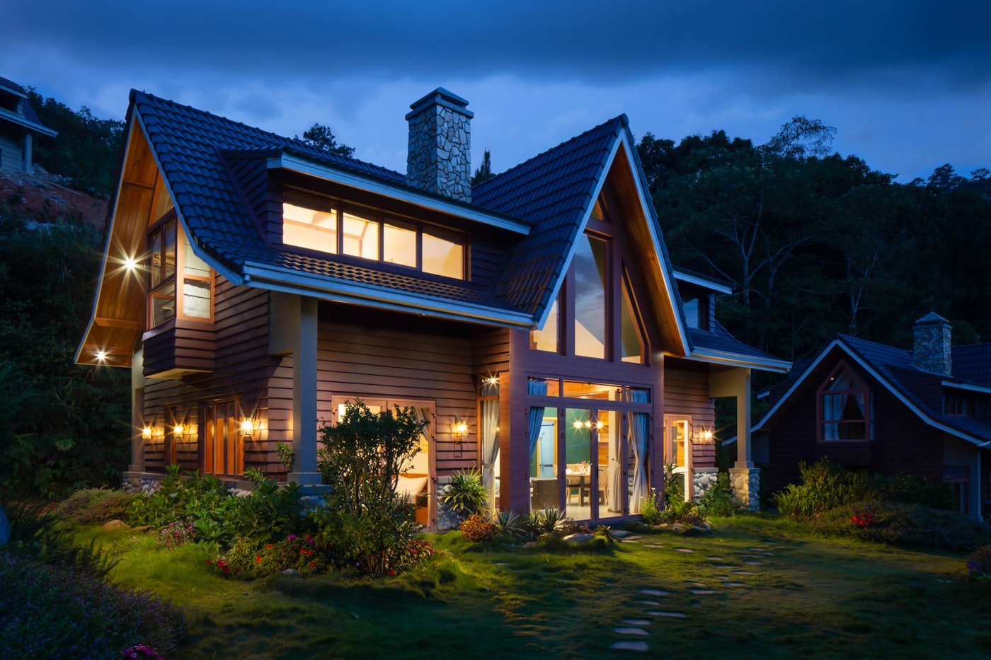 A family house at dusk with its windows lit from inside